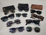 several pairs of sunglasses and a case sitting on a table