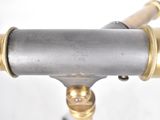 a close up of a brass and silver object on a stand