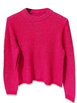 un pull rose sur un cintre, sur fond blanc