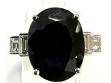 une image représentant une bague ornée d'une grosse pierre noire entourée de diamants