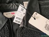 the jacket is black and has a price tag attached to it