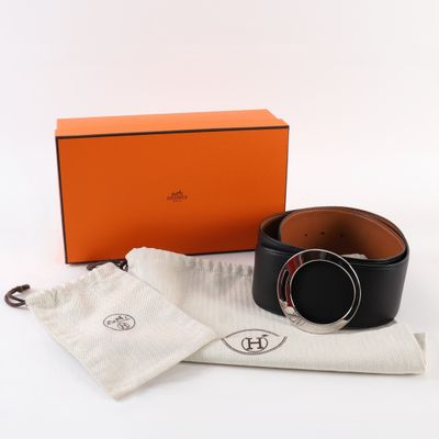 an orange box with a black belt and a white bag