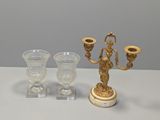 trois vases en verre et un chandelier doré posés sur une table
