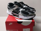 une paire de chaussures noires et argentées posée sur une boîte rouge