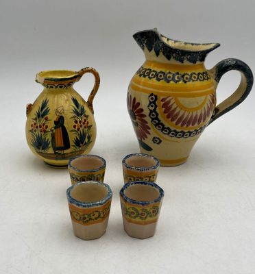 quatre tasses et un pichet posés les uns à côté des autres sur une table