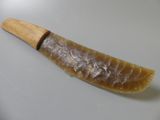a horn shaped object with a wooden handle on a white surface