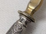 a silver knife with a gold handle on a table