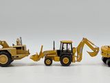 toy construction vehicles are lined up in a row on a white surface