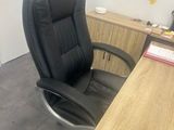 a black office chair sitting in front of a wooden desk