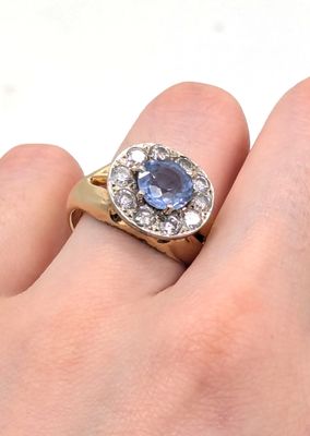 la main d'une femme tenant une bague sertie d'une pierre bleue