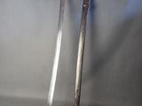 pair of old swords on display against a gray background