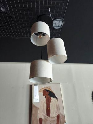 trois lampes suspendues au plafond au-dessus d'un tableau