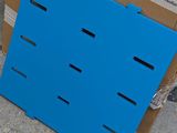 a cardboard box with a blue board on the ground next to a cardboard box with a blue board on the ground