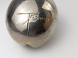 a silver ball on a white surface with a black and white background