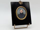 portrait miniature d'un homme en manteau noir, dans un cadre doré
