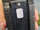 a person holding a black cell phone in their hand