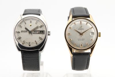 deux montres assises l'une à côté de l'autre sur une surface blanche