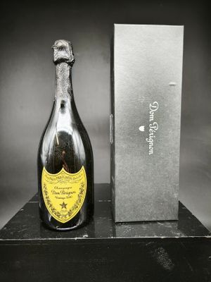 une bouteille de champagne posée sur une table à côté d'un coffret