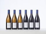 six bottles of wine lined up in a row on a table