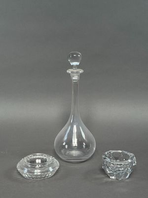 deux bougeoirs en verre et une carafe sur fond gris