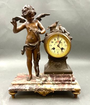 une statue représentant un garçon tenant un oiseau à côté d'une horloge