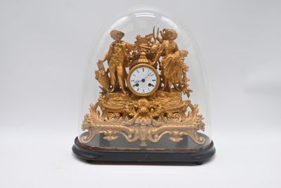 une horloge en or sous un dôme de verre sur une table