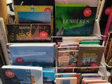 a lot of books that are stacked on a shelf
