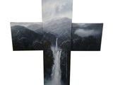a large cross with a waterfall in the middle of it