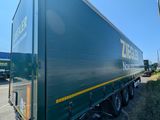 a green semi truck that is parked on the side of the road
