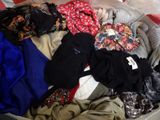une valise remplie de vêtements posée sur un lit