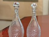two glass salt and pepper shakers sitting on a table