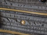 an image of a black purse with gold zippers on it