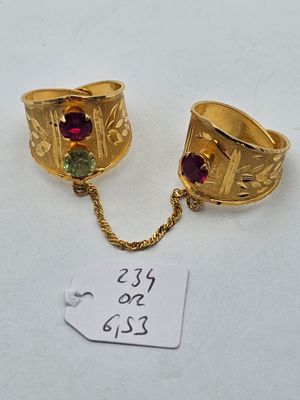 two gold rings with garnets on a chain