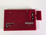 a close up of a red electronic device on a white surface