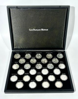 a black box with twelve silver coins in it on a white background