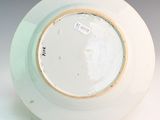 a white plate with a gold rim on a stand