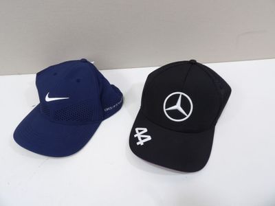 two hats with mercedes logos on them sitting next to each other