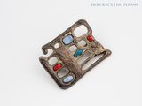 an old silver buckle with red, blue and green stones on it