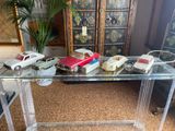 a glass table with a bunch of toy cars on it