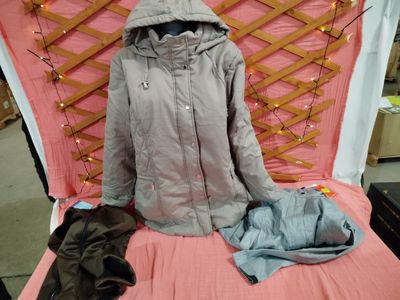 un lit recouvert d'une couverture rose et d'un manteau posé dessus