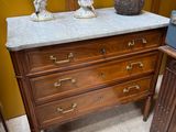 a marble top dresser in a room with a yellow wall