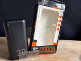 une boîte contenant une batterie externe posée sur une table à côté d'un chargeur