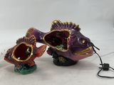 two fish figurines that are sitting on a table