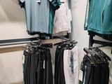 a lot of clothes hanging on a rack in a store