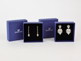 trois paires de boucles d'oreilles dans un coffret cadeau bleu sur fond blanc