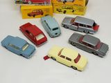 several toy cars are lined up on a table next to a box