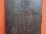 une vieille plaque métallique sur laquelle figurent les portraits d'un homme et d'une femme