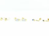 three pairs of gold and blue stone stud earrings on a white surface