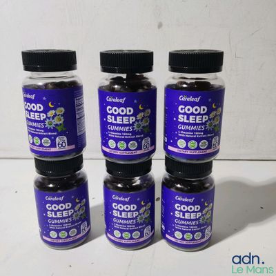 four bottles of good sleep gummies sit on a table