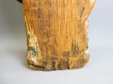 une statue en bois représentant un homme coiffé d'un chapeau